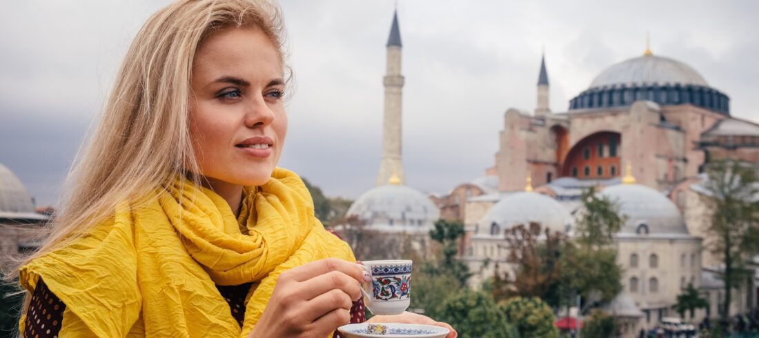 Europe Trip Packages / Woman with turkish coffee on Hagia Sophia background, Istanbul