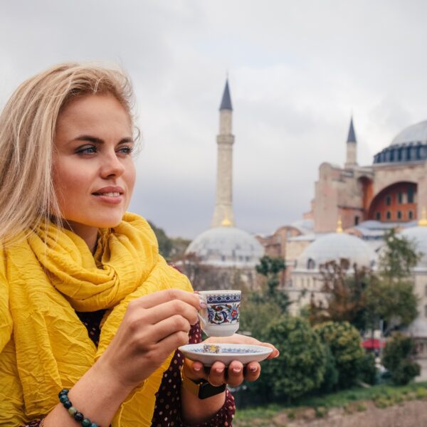 Europe Trip Packages / Woman with turkish coffee on Hagia Sophia background, Istanbul
