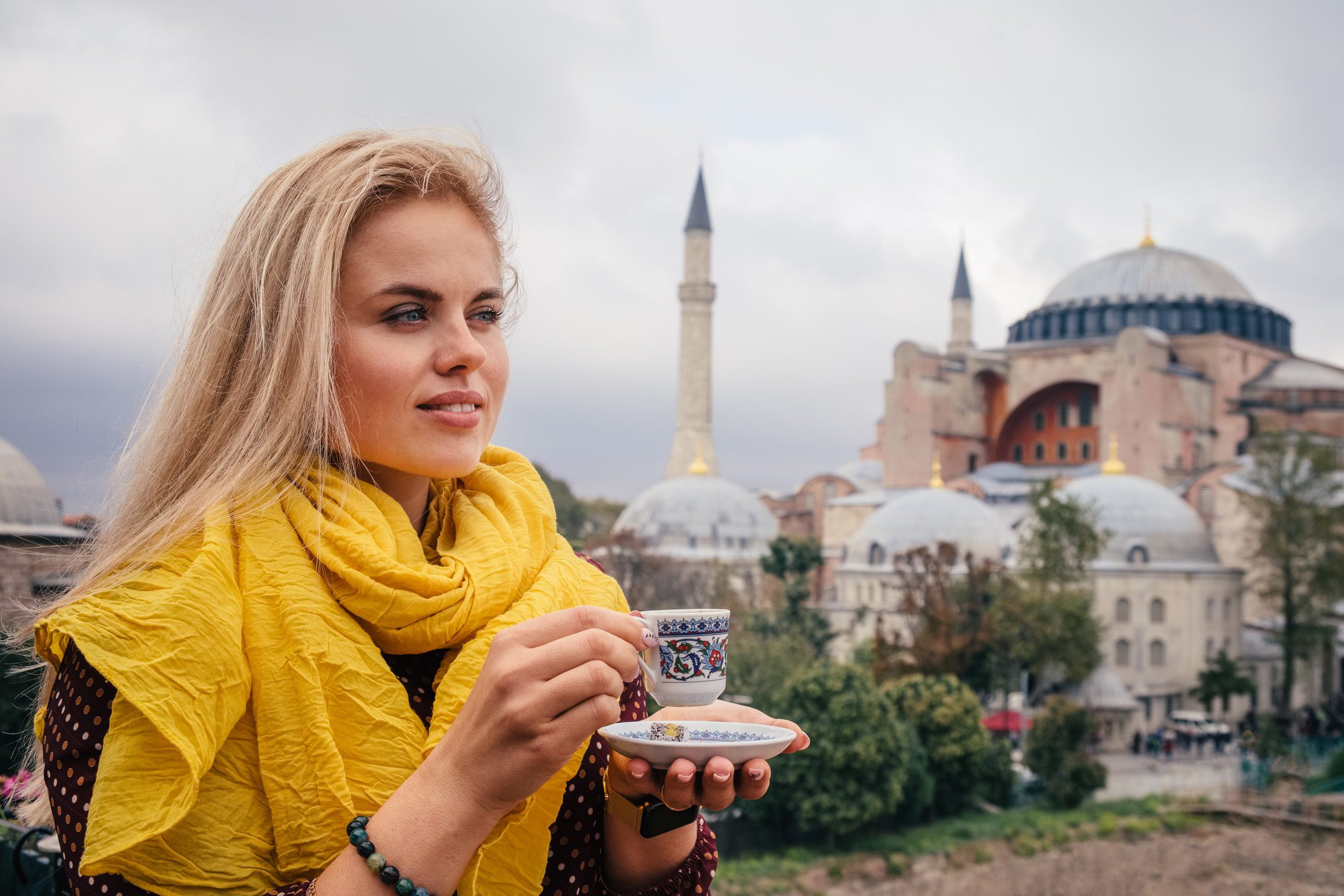Europe Trip Packages / Woman with turkish coffee on Hagia Sophia background, Istanbul