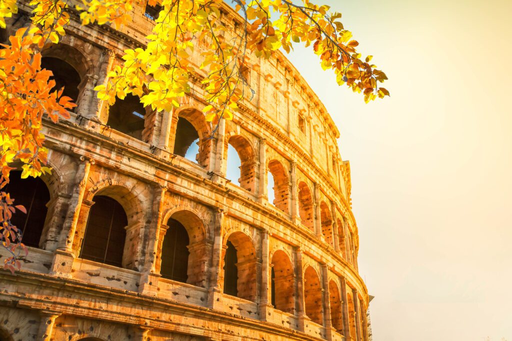 Italy Tours From USA / Ruins of Colosseum at sunrise light in Rome, Italy at fall